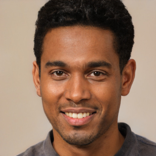 Joyful black young-adult male with short  black hair and brown eyes