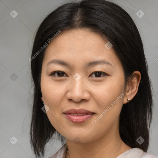 Joyful asian adult female with medium  brown hair and brown eyes