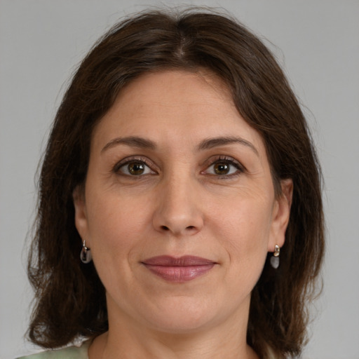 Joyful white adult female with medium  brown hair and green eyes