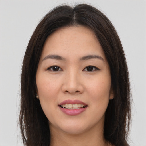 Joyful asian young-adult female with long  brown hair and brown eyes