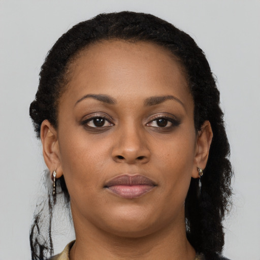 Joyful black young-adult female with long  brown hair and brown eyes