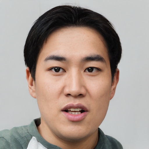 Joyful asian young-adult male with short  black hair and brown eyes