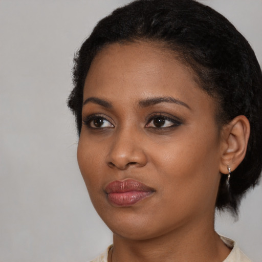Joyful black young-adult female with short  black hair and brown eyes