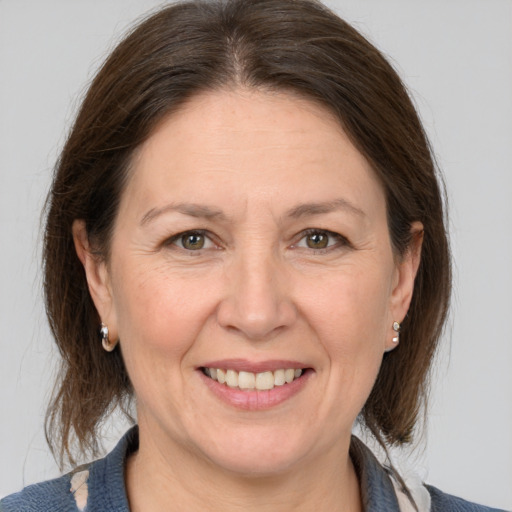 Joyful white adult female with medium  brown hair and grey eyes