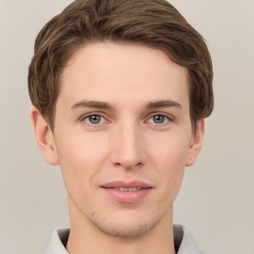 Joyful white young-adult male with short  brown hair and grey eyes