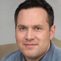 Joyful white adult male with short  brown hair and brown eyes