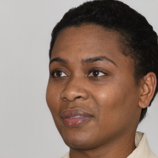 Joyful black young-adult female with short  black hair and brown eyes