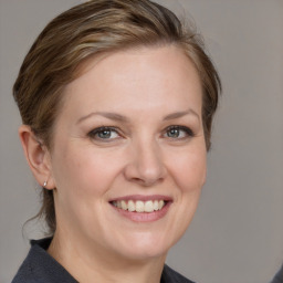 Joyful white adult female with medium  brown hair and grey eyes