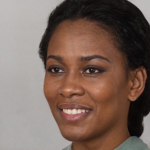 Joyful black young-adult female with short  black hair and brown eyes