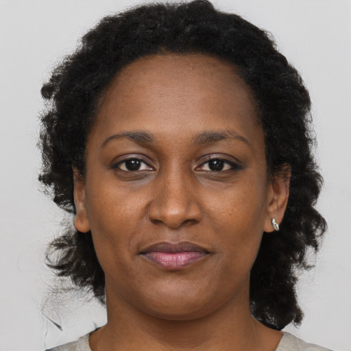 Joyful black adult female with short  brown hair and brown eyes
