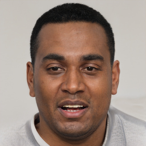 Joyful black young-adult male with short  black hair and brown eyes