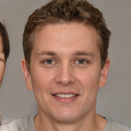 Joyful white adult male with short  brown hair and grey eyes