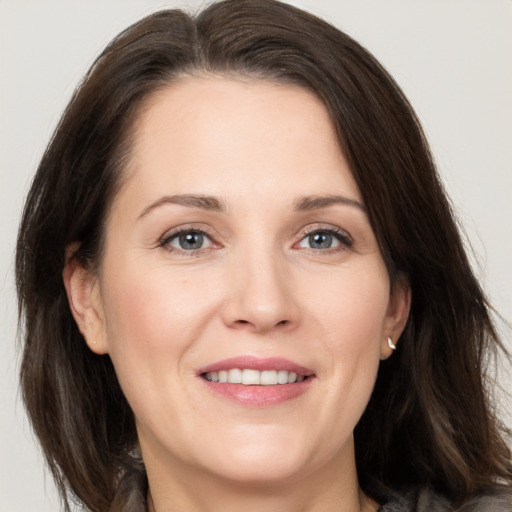 Joyful white adult female with medium  brown hair and brown eyes