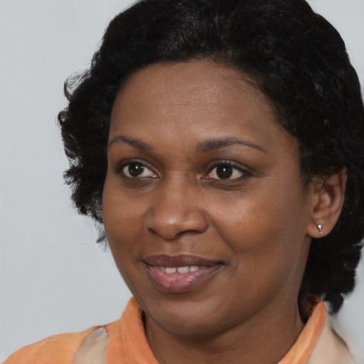 Joyful black adult female with medium  black hair and brown eyes