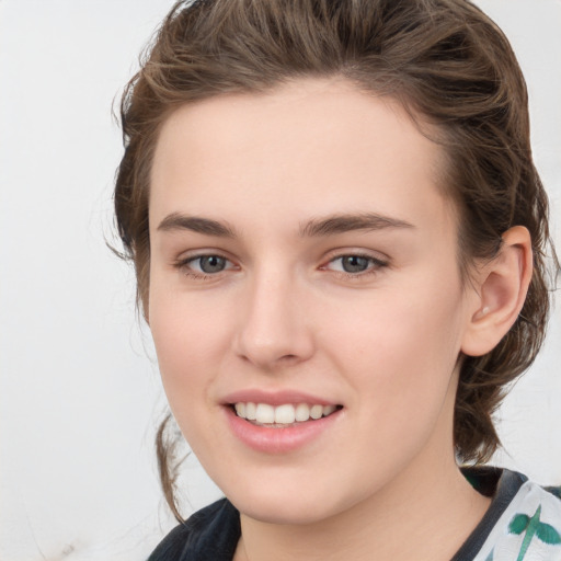 Joyful white young-adult female with medium  brown hair and green eyes