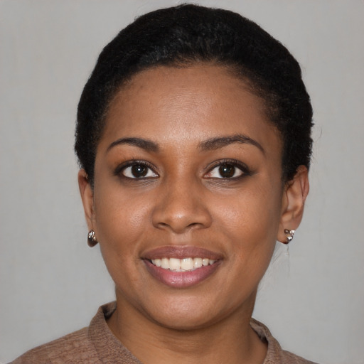 Joyful black young-adult female with short  black hair and brown eyes