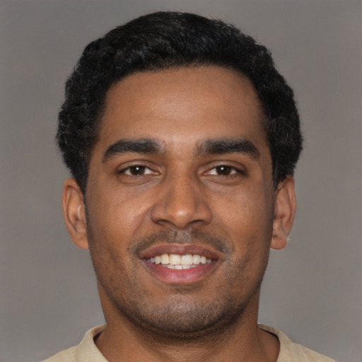 Joyful black young-adult male with short  black hair and brown eyes