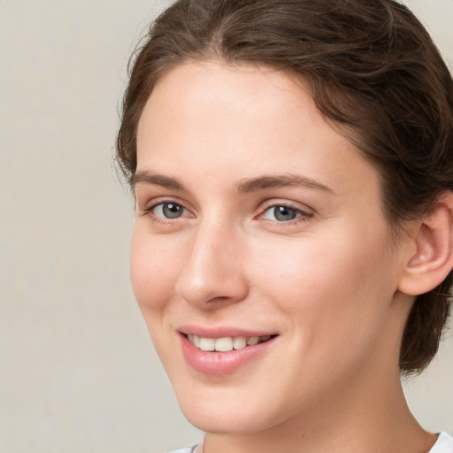 Joyful white young-adult female with medium  brown hair and green eyes