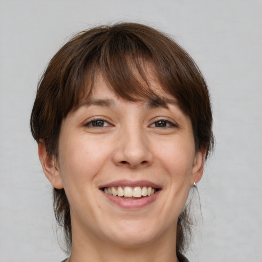 Joyful white adult female with medium  brown hair and brown eyes