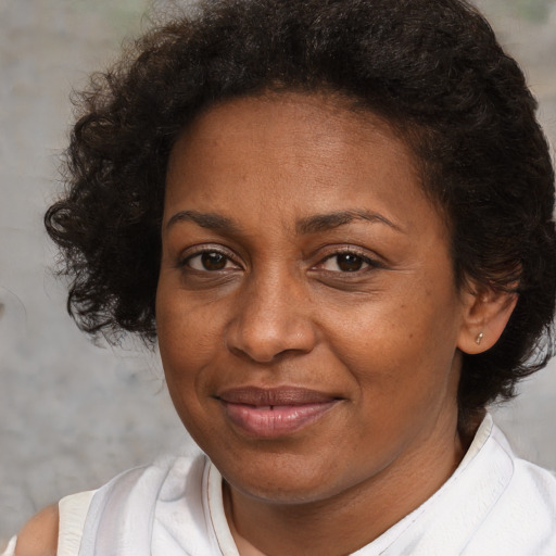 Joyful black adult female with medium  brown hair and brown eyes