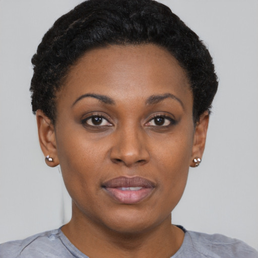 Joyful black young-adult female with short  black hair and brown eyes