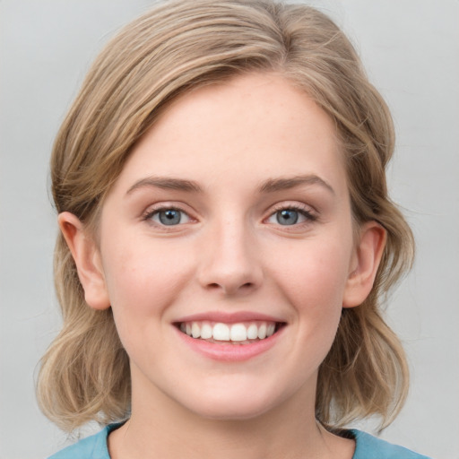 Joyful white young-adult female with medium  brown hair and blue eyes