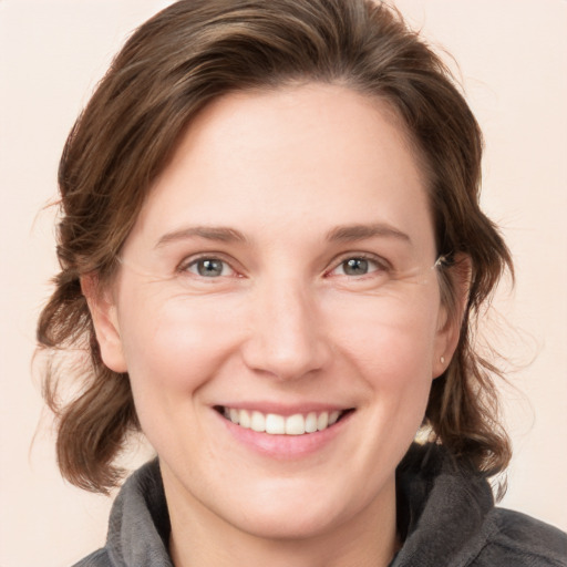 Joyful white young-adult female with medium  brown hair and blue eyes