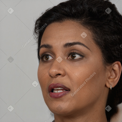 Joyful black young-adult female with long  black hair and brown eyes