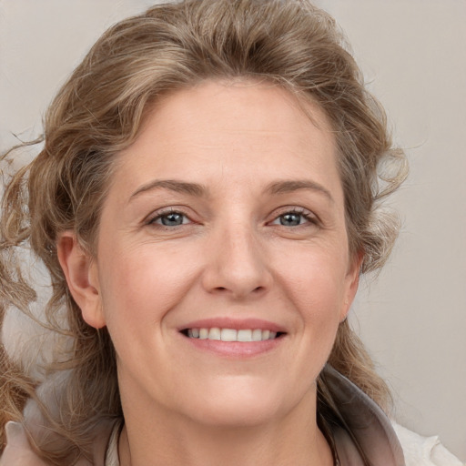 Joyful white adult female with medium  brown hair and grey eyes