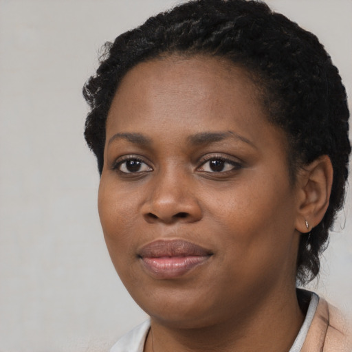 Joyful black young-adult female with short  black hair and brown eyes