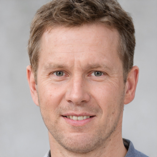 Joyful white adult male with short  brown hair and grey eyes