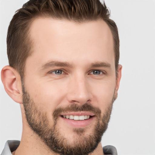 Joyful white young-adult male with short  brown hair and grey eyes