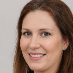 Joyful white adult female with long  brown hair and brown eyes