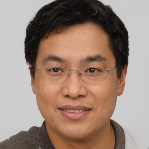 Joyful asian adult male with short  brown hair and brown eyes