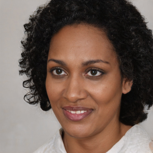 Joyful black adult female with medium  brown hair and brown eyes