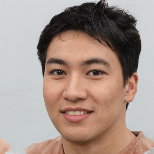 Joyful asian young-adult male with short  brown hair and brown eyes
