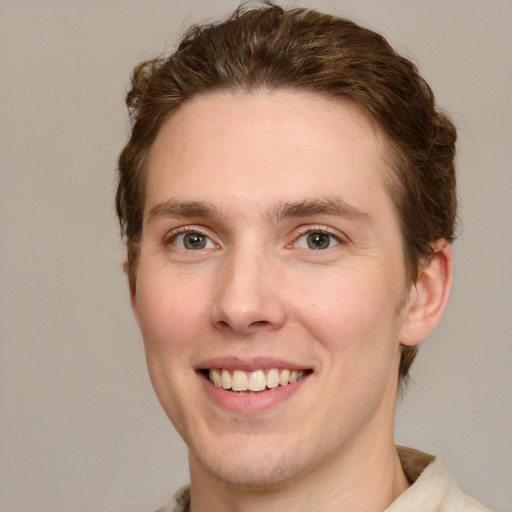 Joyful white young-adult male with short  brown hair and green eyes