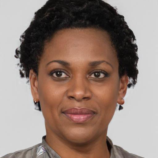 Joyful black adult female with short  black hair and brown eyes