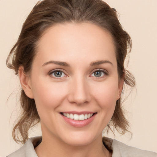 Joyful white young-adult female with medium  brown hair and grey eyes