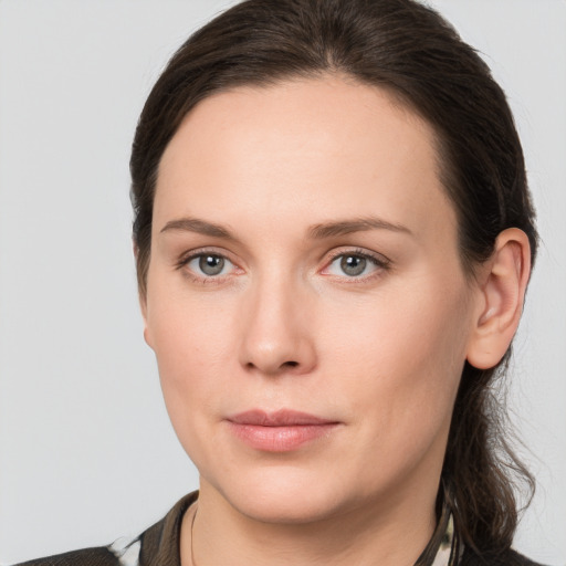 Joyful white young-adult female with medium  brown hair and grey eyes