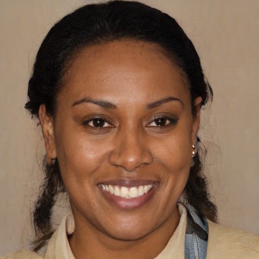 Joyful black adult female with medium  brown hair and brown eyes