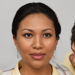 Joyful latino young-adult female with medium  brown hair and brown eyes