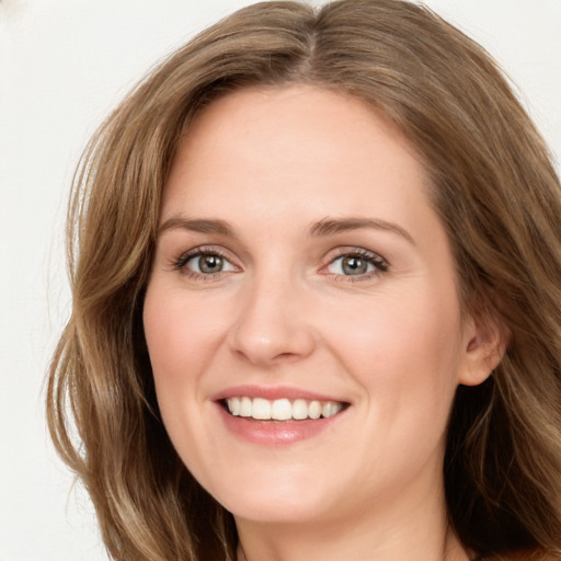 Joyful white young-adult female with long  brown hair and green eyes