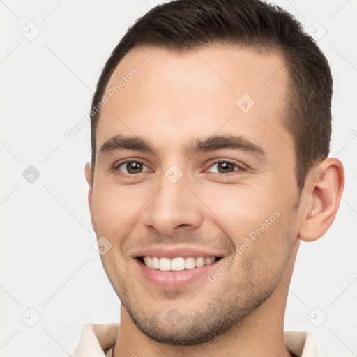 Joyful white young-adult male with short  brown hair and brown eyes