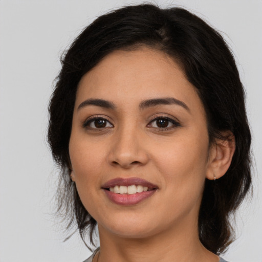 Joyful latino young-adult female with medium  brown hair and brown eyes