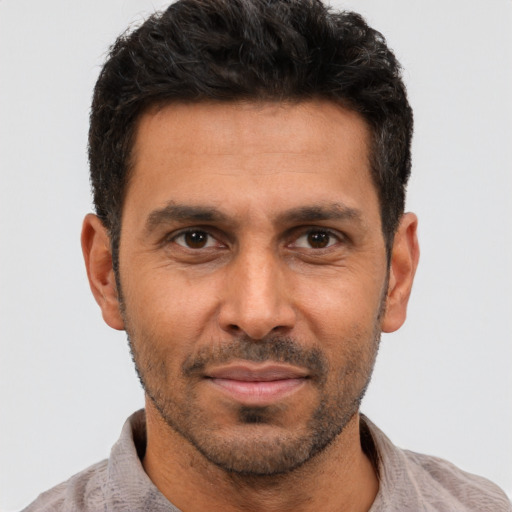 Joyful white adult male with short  black hair and brown eyes