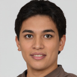 Joyful latino young-adult male with short  brown hair and brown eyes