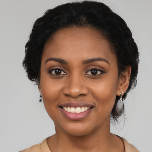 Joyful black young-adult female with long  black hair and brown eyes