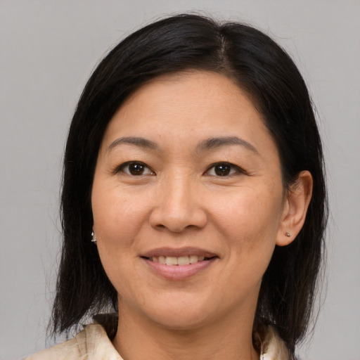 Joyful asian adult female with medium  brown hair and brown eyes