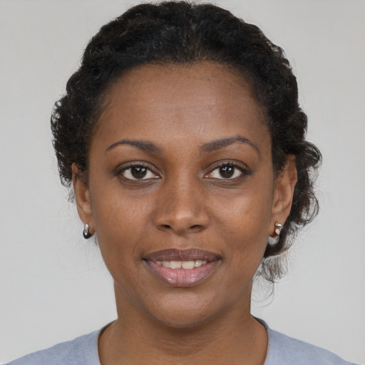 Joyful black young-adult female with short  brown hair and brown eyes
